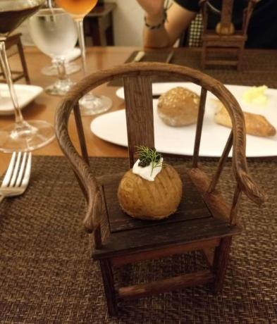 pasniedzot kartupeļus uz bērnu krēsla