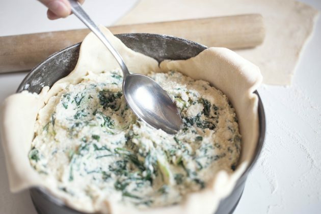 Itāļu siera pīrāgs: recepte. Vienmērīgi izklājiet siera pildījumu un ar karoti izveidojiet trīs ievilkumus.