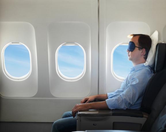 Portrets vīrietis atpūšoties lidmašīnā